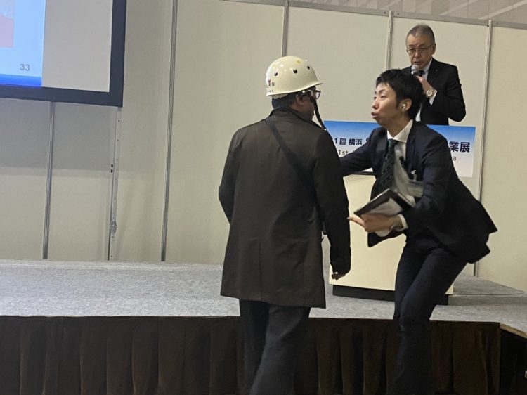 橫濱副市長於首屆日本IR博覽會上被反對賭場的示威人士打斷演講